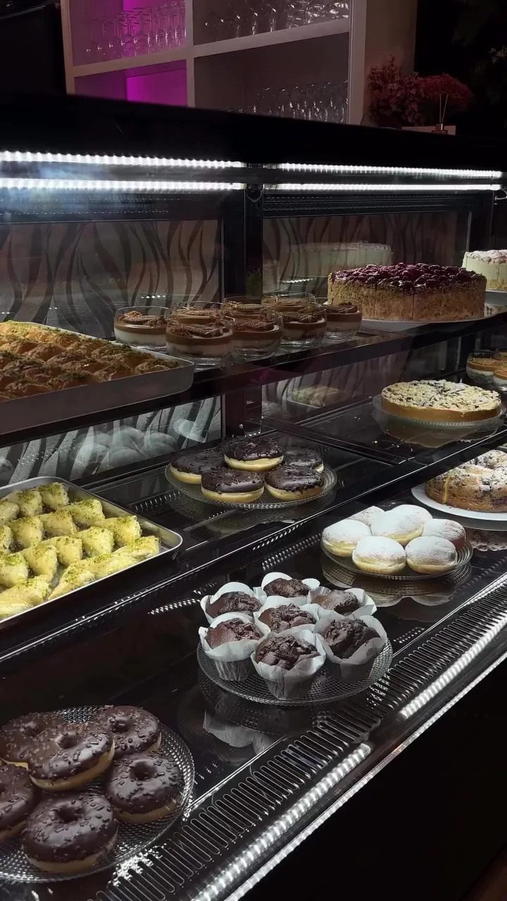 Kuchenvitrine mit Torten, Baklava und Donuts